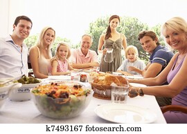 A family, with parents, children and grandparents, enjoy a picnic A family, with parents, children and grandparents, enjoy a picnic
