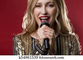 Calm woman holding mike with two hands and chanting