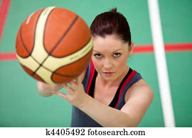 Portrait of an athletic young woman playing basket-ball