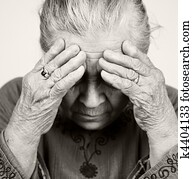 Sad old senior woman with health problems