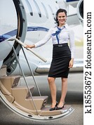 Stewardess Standing On Ladder Of Private Jet