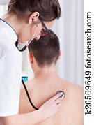 Doctor examines the patient's lungs