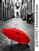 Red umbrella on cobblestone street in the old town. Wind and rain Red umbrella on cobblestone street in the old town. Wind and rain