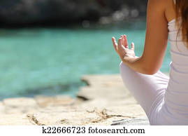 Detail of a woman hand doing yoga exercises on the beach