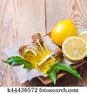 Organic essential lemon oil with green leaves and fruit Organic essential lemon oil with green leaves and fruit