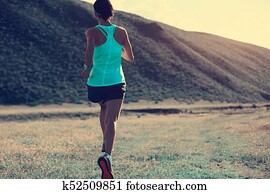 young fitness woman trail runner running on mountain grassland young fitness woman trail runner running on mountain grassland