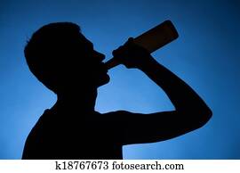 young man drinking alcohol from bottle. young drunkard holding bottle and standing young man drinking alcohol from bottle. young drunkard holding bottle and standing