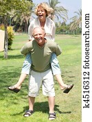 image of Senior man giving woman piggyback ride image of Senior man giving woman piggyback ride