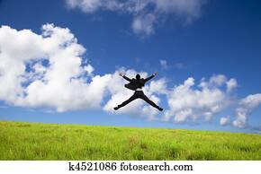 happy and successful Businessman jumping on a green meadow 