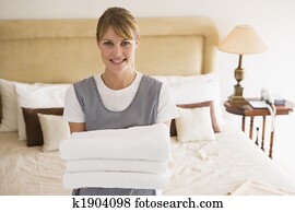 עוזרת בית, להחזיק, מגבות, ב, חדר של מלון, לחייך