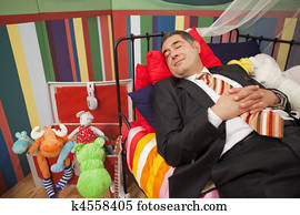 Mature man sleeping in playpan
