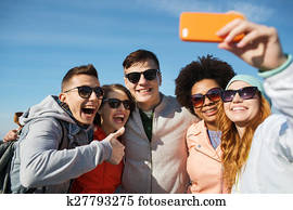 smiling friends taking selfie with smartphone smiling friends taking selfie with smartphone
