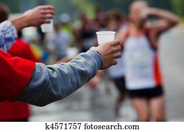 Runner take a water in a marathon race Runner take a water in a marathon race