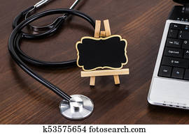 the doctor's desk with laptop, stethoscope and blackboard with empty space for a text