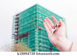 A real estate agent holding keys to a new apartment in her hands.