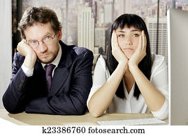 Unhappy business people sitting on desk depressed