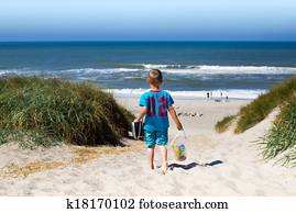 Boy walking towards beach