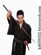 Youg martial artist practicing Iaido with a sword and with typical japanese kimono. 