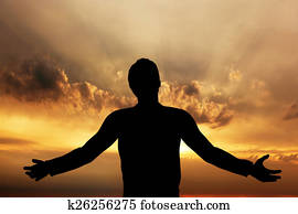 Man praying, meditating in harmony and peace at sunset Man praying, meditating in harmony and peace at sunset