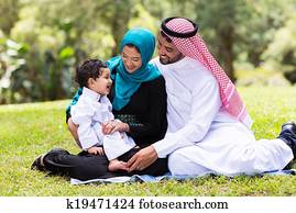 muslim family sitting outdoors muslim family sitting outdoors