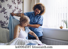 Home caregiver dressing senior Home caregiver dressing senior