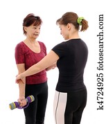 Senior woman exercising with coach 