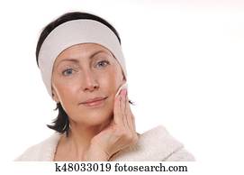 portrait of pretty senior woman taking off makeup portrait of pretty senior woman taking off makeup