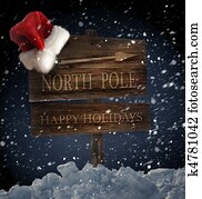 Wooden sign with santa hat on snowy background Wooden sign with santa hat on snowy background