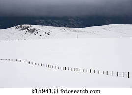 Snowy field with fence. 