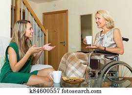 Female friend visiting disabled woman Female friend visiting disabled woman