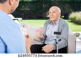 Male Caretaker And Senior Man Playing Cards