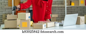 Online seller works at home office and packs shipping delivery box to customer. Online seller works at home office and packs shipping delivery box to customer.