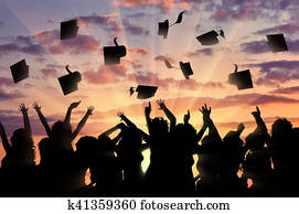 Graduates sunset throw graduate cap Graduates sunset throw graduate cap