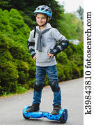 Happy boy riding on hoverboard or gyroscooter outdoor