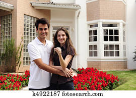 Happy homeowners infront of new house