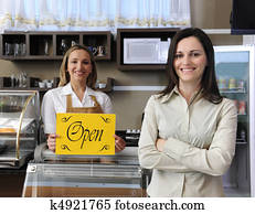 Happy owner of a caf? showing open sign Happy owner of a caf? showing open sign