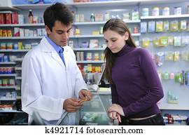 Pharmacist advising client at pharmacy Pharmacist advising client at pharmacy