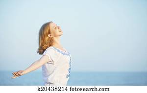 happy young woman open her arms to the sky and sea