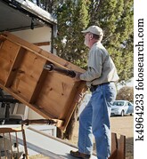 Senior Man Moving a Table Senior Man Moving a Table