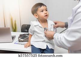 Pediatrician doctor examining a little asian boy by stethoscope Pediatrician doctor examining a little asian boy by stethoscope