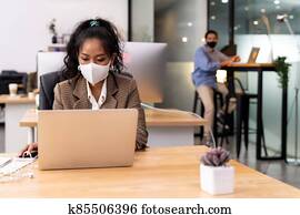 African office worker with asian team in new normal social distance office