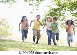 Five young friends running outdoors smiling Five young friends running outdoors smiling
