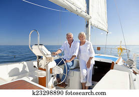 Happy Senior Couple At The Wheel of a Sail Boat
