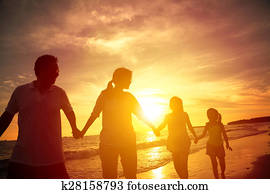The silhouette of happy family walking on the beach