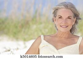 Attractive Elegant Senior Woman Sitting At A Beach