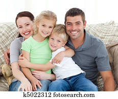 Adorable family sitting on the sofa and smiling Adorable family sitting on the sofa and smiling