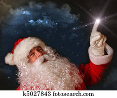 Santa pointing with magical light to the sky
