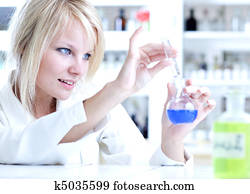 Closeup of a female researcher holding up a test tube and a retort and carrying out experiments