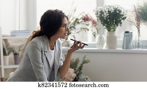 Caucasian woman talk on cell using voice assistant Caucasian woman talk on cell using voice assistant