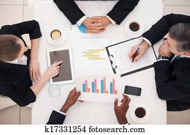 Business meeting. Top view of business people in formalwear sitting at the table and discussing something Business meeting. Top view of business people in formalwear sitting at the table and discussing something